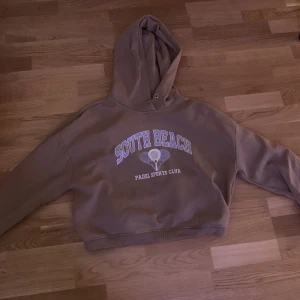 En hoodi. - Den är tvättad. Och har lila tryck.