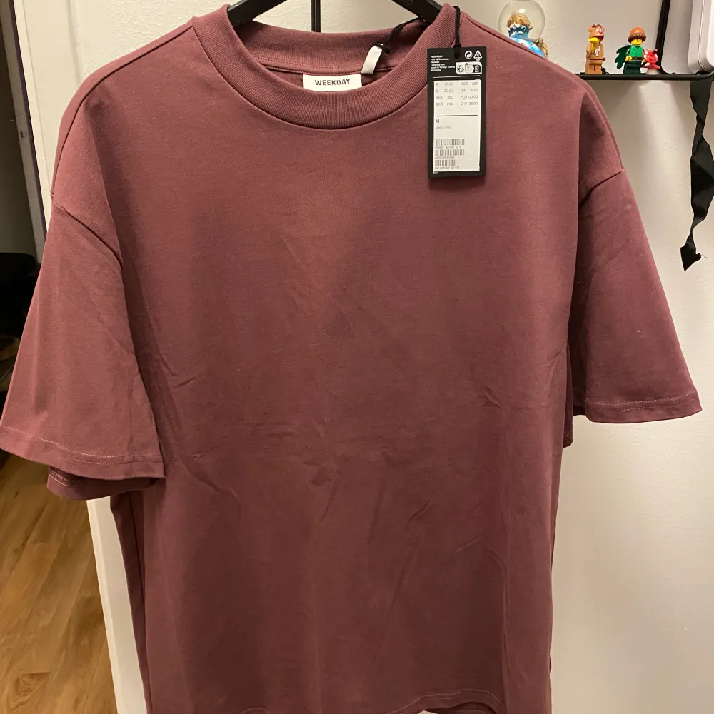 En lila Weekday t-shirt i storlek M.. T-shirts.