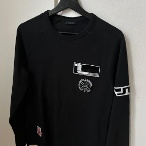 J.Lindeberg, Tröja med märken, Strl S - Fint skick. Säljs pga för liten för mig. Strl S.