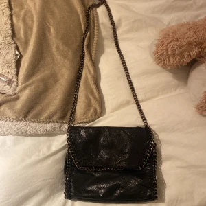 Shimmrande Väska med kedja - Väska orginellt från Ullared, den är använd och har märken av användning på kedjan, frakt kostar 66kr som köpare står för❤️