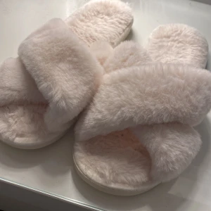 Mysigaste innetofflorna - Säljer dessa gosiga innetofflor från glitter,dem är i storlek 40/41 och aldrig använda därav i väldigt fint skick💗