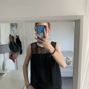 Svart blus - Svart Vero Moda blus med spets över axlarna och dragkedja i ryggen. Storlek S. Mycket fint skick. 