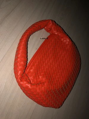 Bottega vinetta inspirerad väska!  - Säljer denna jätte fina vävda väskan från nakd som nästan är identisk med den omtalade bottega väskan! Jätte fin orange röd färg som livar upp en outfit jätte fint! Men använder den inte så mkt längre! 
