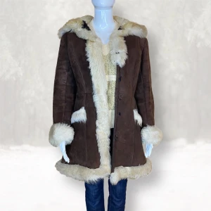 Vinterjacka - Från Smi, svensk tillverkning. Finns ingen materiallappen men tror det är äkta skinn & päls. Knapparna för att stänga är lösa. Kan nog sys tillbaka. Mått: Axel till axel 47.5, armhåla till armhåla 51cm, ärmlängd 59cm, längd 85cm & midjebredd 43cm