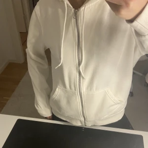 Zipup HM - En fin vit zip up hoodie från HM lite ”oversized” nyskick, knappt använd endast 2 gånger max. Säljer då jag känner att den inte riktigt passar mig. Köparen står för frakten, säljer för 120kr!