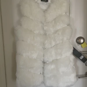 NY VIT PÄLSVÄST FUSKPÄLS 38 - Super snygg varm fuskpäls väst perfekt över en varm tröjja eller skinnjacka. Storlek 36/38