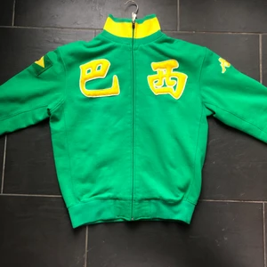 Kappa Brazil zip up - Fin zip up i bra skick med ”巴西” på bröstet. (Betyder Brasilien). Står Brazil i nacken, har Brasiliens flagga på höger arm och kappas märke broderat på vänster.