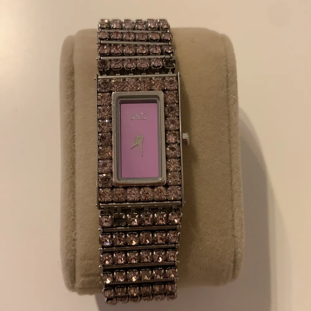 DOLCE GABBANA D&G klocka med rosa swarovski crystals stenar, några saknas men det syns knappt.  Mått runt 15cm Behöver nytt batteri  Nypris 4000. Accessoarer.