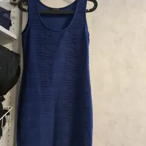 En blå klänning som har lite vågor på sig i mönster. Väldigt skön moch mjuk i materalet.  Har inga skador. 