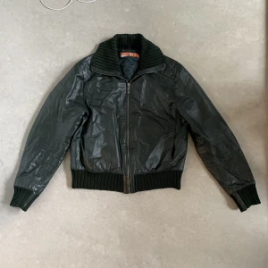 Kobayashi läderjacka - Vacker läderjacka köpt i vintagebutik. Mörkgrön, utan skador eller fläckar. Storlek L men med en liten passform. Jag är 185cm lång.