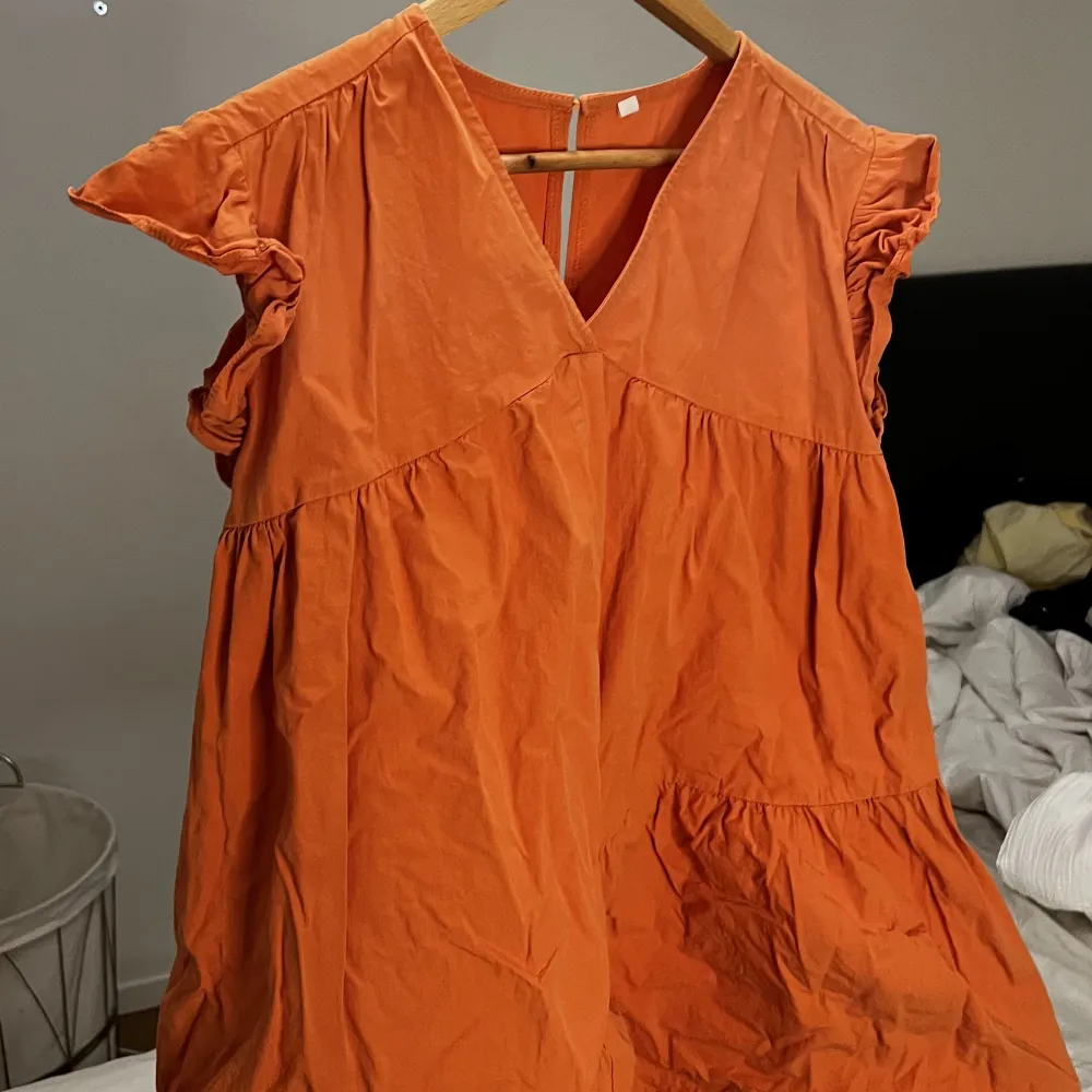 orange klänning med volanger, köpt här på plick och endast använd 1 gång av mig🫶🏽färgen i verkligheten är som på första bilden. Klänningar.
