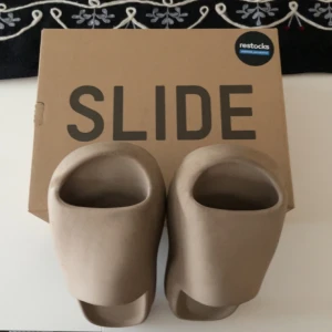 Yeezy slide pure - Säljer nu mina yeezy slide  som är använda ett par gånger. Det här är perfekt till dig som idrottar ifall du vill ha ett par sköna tofflor efter match. Det är perfekt till sommarn och väldigt sköna och gå i. Köpte för 2,2 på restock. Pris kan diskuteras!!