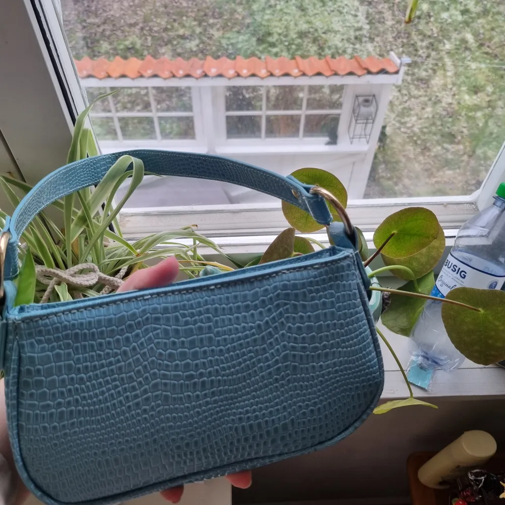 Säljer en jättefin blå liten handväska från asos. Använd 1 gång så som ny. Säljer då den inte kommer till användning. 200kr + frakt💕. Väskor.