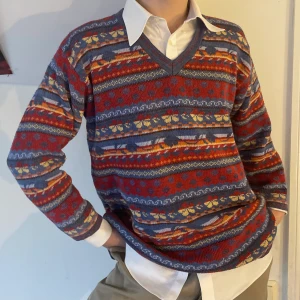 Vintage stickad mönstrad v-ringad röd gul blå tröja - Supermysig röd, gul och blå vintsge stickad tröja med randigt och blommigt mönster och v-ringning 🌼 Så fin med en skjorta under till våren eller till stranden mot sommaren!