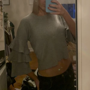 Grå Volangtröja bikbok vintage y2k croptop long skrevs långärmad tröja - Grå tröja i tjockare material från bikbok, använd enstaka gånger, i perfekt skick. Volanger på armarna, lite kortare i modellen. 