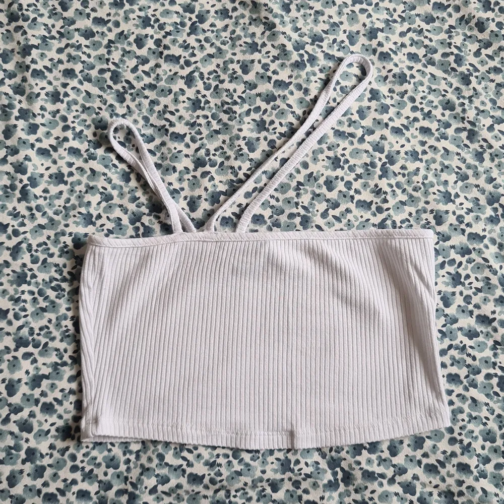 White crop top with a cross shoulder strap.  Size 36. Toppar.