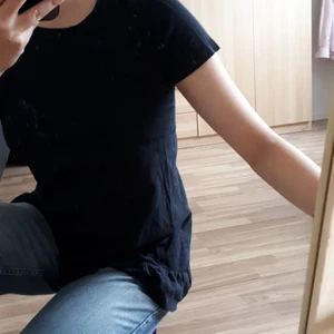 Svart t-shirt med volang - Längre svart t-shirt med volanger i kanten!🖤 Kan klippas av om man föredrar det🤔😅 Barnstorlek men passar på mig som har allt från XS till M, så skulle gissa att den passar XS-M. OBS smutsig spegel