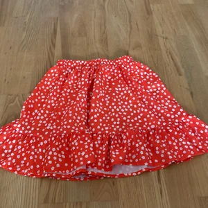 Röd blommig kjol st 140 - Röd blommig kjol i bra skick med resor band i midjan 