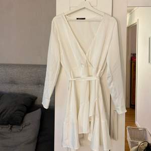 En jättefin vit klänning från GinaTricot som endast är använd en gång. I storlek 38. Man kan knyta antingen fram eller bak. Säljes för 150 kr+frakt