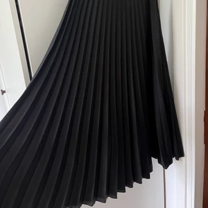 Svart plisserad kjol - Strl 36!
