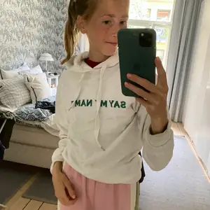 Vit hoodie från NAKD med grön text.