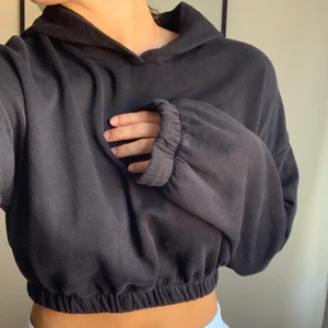 Croppad hoodie - En kort svart hoodie från Nelly som sitter åt vid midjan och ärmarna. Storlek m men ganska kort! Använd en del men fint skick!!🖤 frakt tillkommer