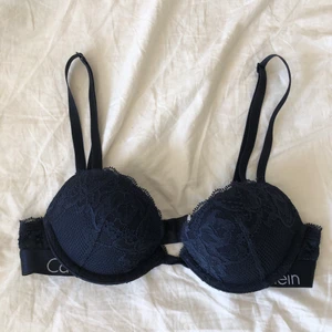 calvin klein bh - mörkblå bh från calvin klein, använd men i fint skick. har klippt bort lappen där storleken står men är 99% säker på att den är 70A, har lite pushup. frakt 26kr, postar efter betalning med swish!