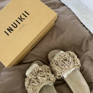 INUIKII tofflor - Snygga beigea INUIKII tofflor i mycket bra skick, endast använda en gång. Storlek 39. Köpta för 2 285 kr och mitt pris 1 000 kr men priset går att diskutera.