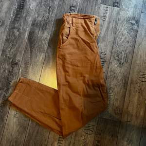 Ljusbruna/orangea högmidjade byxor. De är mjuka och bekväma. Köpte dessa 2019 och har inte använt de så mycket så de är i bra skick