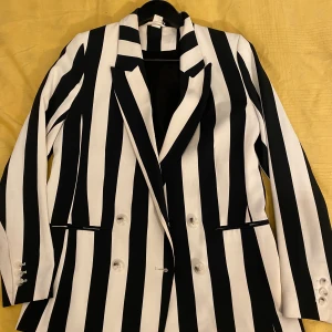 H&M Svart och vit kavaj Size S  - H&M Kavaj  En dubbelknäppt kavaj i vävd kvalitet med krage och slag. Kavajen har framfickor och dekorativ knäppning vid ärmslut. Rak passform. Fodrad  Har haft på mig den några gånger. Har lite fläk på kragen från hår gel som kommer bort med kemtvätt. 