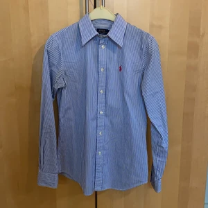 Ralph Lauren skjorta  - Vit/blå randig skjorta. Figursydd i storlek 4, motsvarar XS