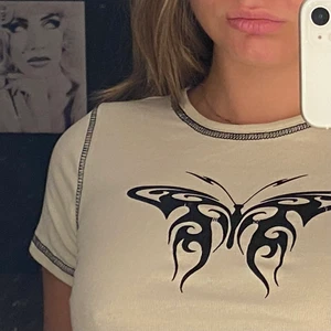 Beige och svart topp  - Beige topp med svarta sömmar med en fjäril på 🦋  aldrig använd. Har en liknande vit också (finns i min profil) 