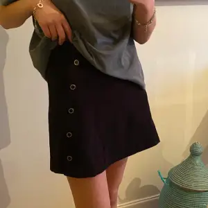 Superfin svart kjol med knappar på sidan! 