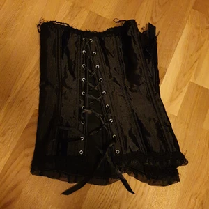 Laced korsett med band och rosett  - En svart korset i onesize som jag köpte för 199 kr. Användts cirka 5 gånger. Hittar inget märke på den. Jätte fin korsett som går att knyta tajt! Passar mig perfekt som har storlek S och ibland XS.💕 köparen står för frakten och pris kan alltid diskuteras.