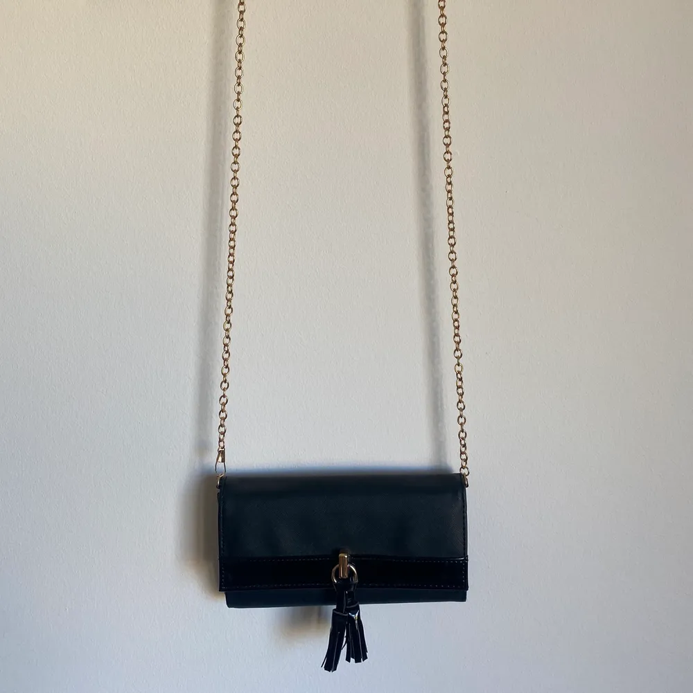 Snygg liten svart crossbody väska med dragkedja på insidan. Guldiga detaljer. . Väskor.