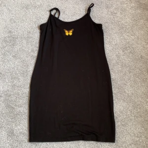 Klänning - Svart klänning med tryck, reglerbara band. Använd en gång, väldigt skönt material. Perfekt att ha på våren och sommaren☀️