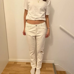 Raka Lågmidjade vita jeans - Ett par lågmidjade vita jeans med hål på ena knäet. Så fina till sommaren!