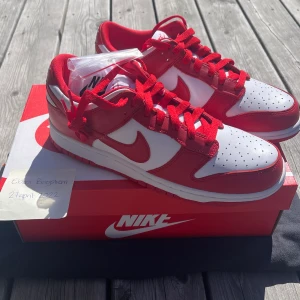 Nike dunk low SP White/university red - Säljer ett par sprillans nya Nike dunk low i färgen white/university red. Aldrig använda. Det ingår ett par extra snören i färgen vit. Frakten ingår i priset men går även bra att mötas upp i Växjö eller Jönköping.☺️