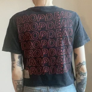 Drop Dead T-shirt  - Drop Dead T-shirt   Med rött tryck på ryggen   Använd men i toppen skick   Storlek uk 6 ( xs ) 