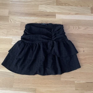 Kjol svart  - En svart volang kjol från Gina tricot i storlek 36