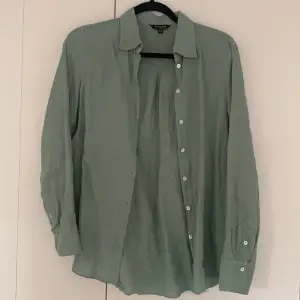 Grön Linneskjorta i 100% linne med pärlemoknappar från Massimo Dutti i storlek 34. Sparsamt använd.