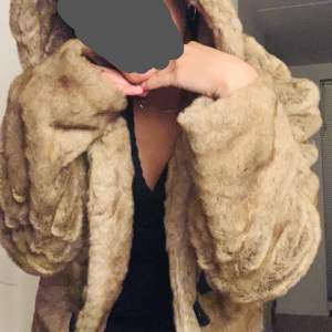 Fake furry coat, very smooth and elegant, the size dis XL but I’m an S-M so I guess it fits most people depending on your taste. 