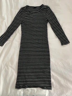 Randig klänning  - Randig svartvit midilång klänning från Gina Tricot