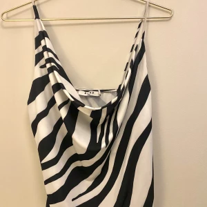 Topp i zebramönster - Säljer denna festtoppen från NA-KD med zebramönster i storlek 34. Stretchigt material och endast använd vid ett tillfälle!