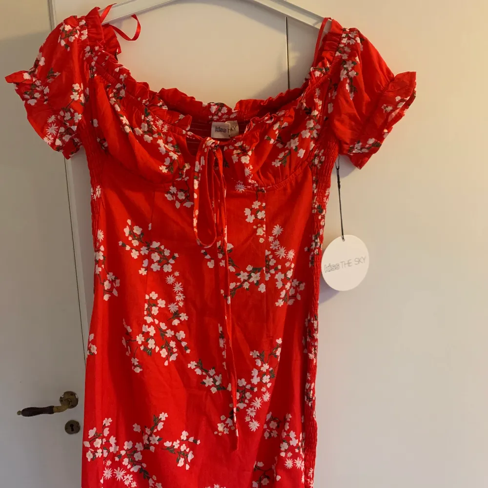 Jättefin röd klänning med blommor, fina detaljer. Aldrig använd.. Klänningar.
