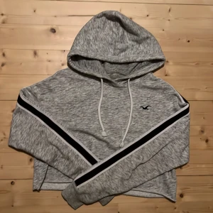 Kroppar grå hoddie - Jag säljer en grå kroppar hoddie med sträck på ärmarna i färgerna svart röd och vit. Hoddien är från hollister och är i storleken xs. Ordinarie priset är 420 kr men jag säljer den för 100 kr +frakt.