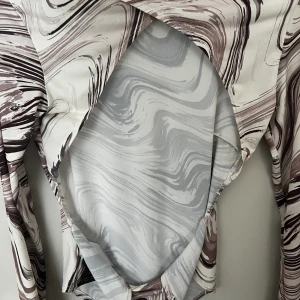 Body från Nelly  - Mönstrad snygg body, aldrig använd 