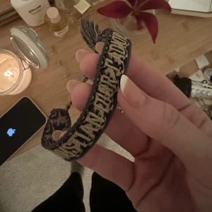 Christian Dior armband - Säljer mitt armband från Dior, självklart äkta och bevis på detta medföljer. Ena toffsen är lite skadad, därav priset (dock inget man ser) 