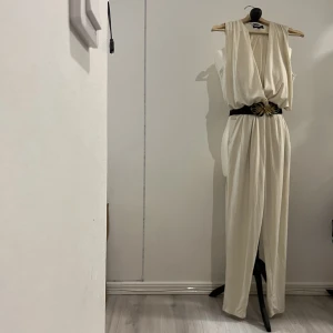 Jumpsuit - Nyskick!! Krämig Jumpsuit i stretch tyg. Väldigt fint med ett skärp till. Skärp på bild medföljer inte.