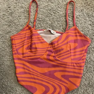 Linne - Ett väldigt unikt mönstrat linne med starka orangea o rosa färger. Sitter som en smäck har även ett väldigt stretchigt material. Passar till allt. Använd ungefär 4 gånger men finns inga tecken på användning 💗vid fler frågor/bilder👉🏼köparen står för frakt